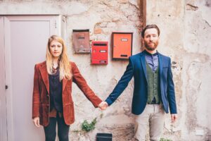 Young couple in love holding hands standing front door